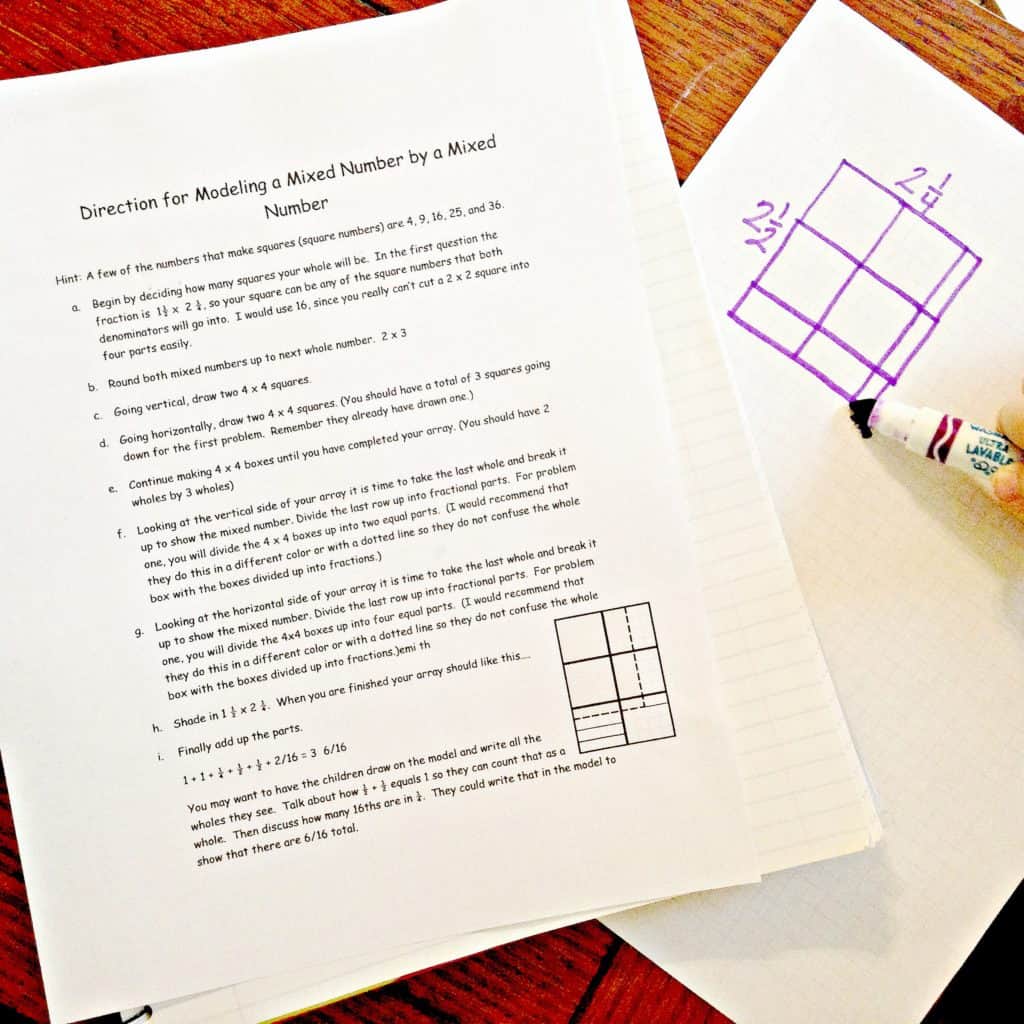 A how-to multiply mixed fractions worksheet on a wooden table. 
