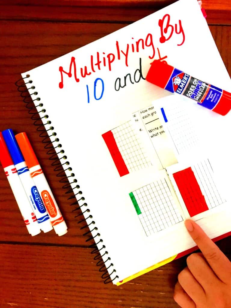 Multiplying decimals worksheet on a table with markers and glue.  