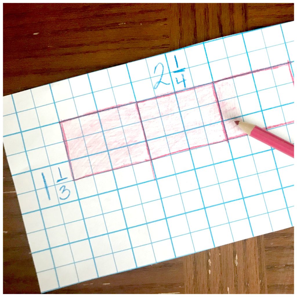 Multiplication arrays game worksheet on a wooden table with a pink pencil crayon. 
