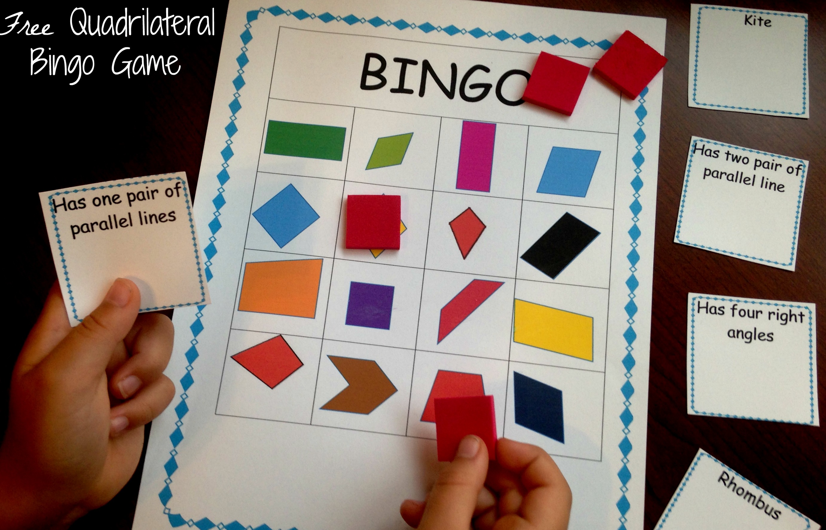 Quadrilateral bingo with a child's hands holding game pieces.