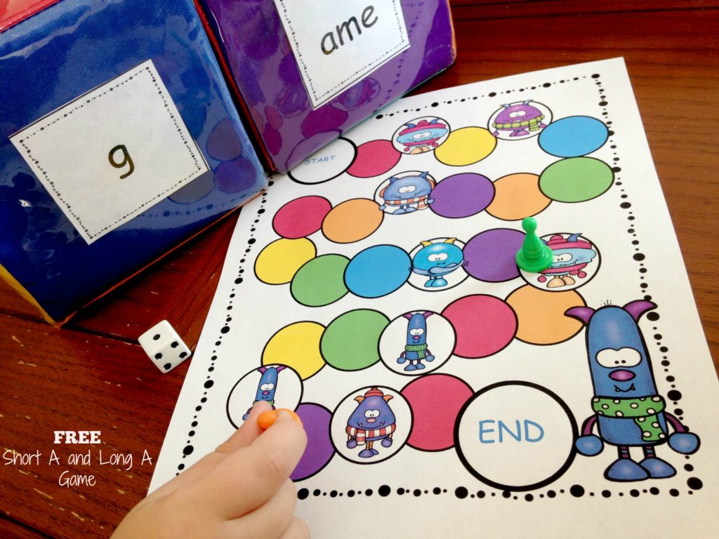 Short A vs Long A game on a wooden table with dice and game pieces. 