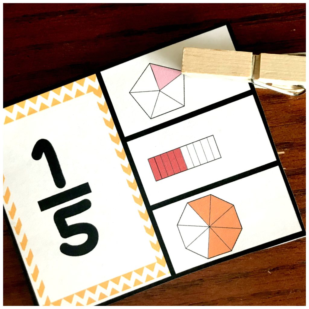 Visual fraction model clip cards on a wooden table with a clothespin. 