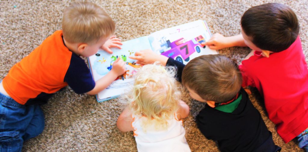 Children reading a storybook about race cars.  