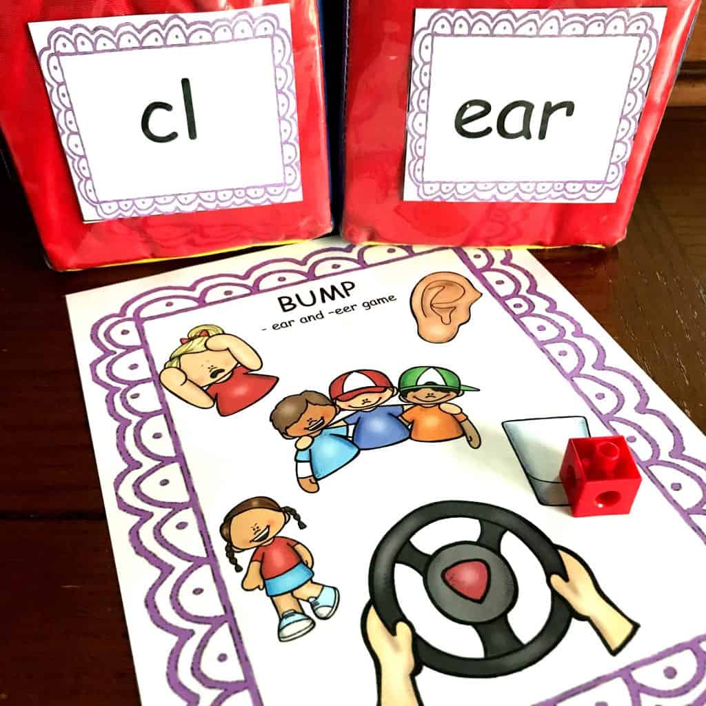 EAR word phonics game with large dice. One dice says, "cl" and the other dice says "ear". There is a worksheet with various pictures on it. 