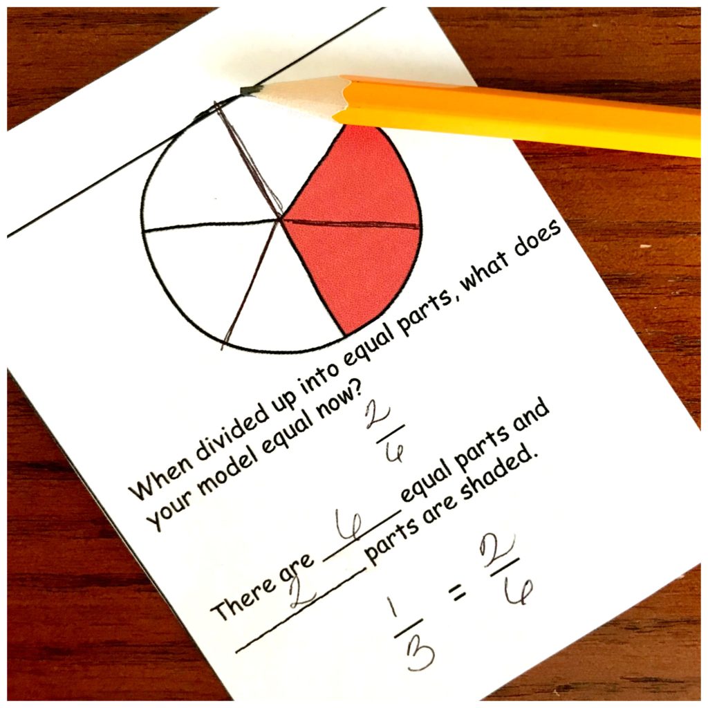 Equivalent fractions cards on a table filled out with the answer. 