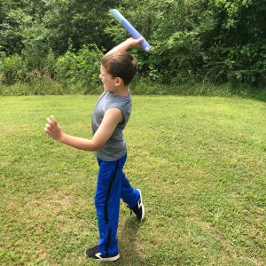 STEM Measurement Activities for 2nd Grade with a little boy throwing his paper javelin outside. 