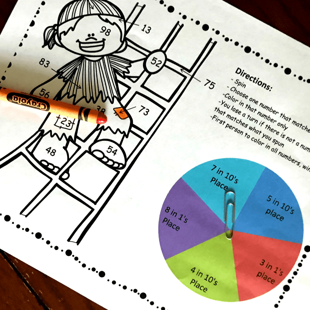 Place value color by number worksheets with a pirate climbing a latter that is being colored with an orange crayon. 