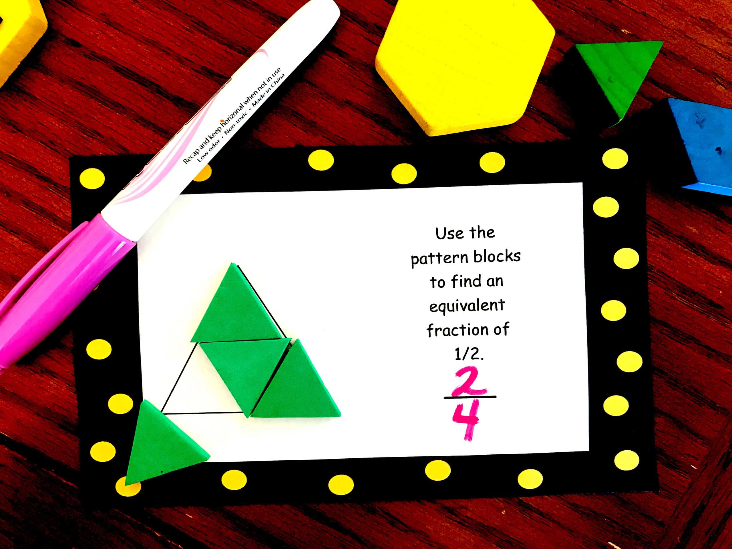 Fractions with pattern blocks task cards on a wooden table.