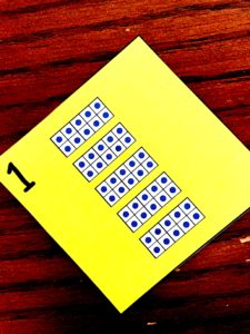 Place value bingo cards on a wooden floor.