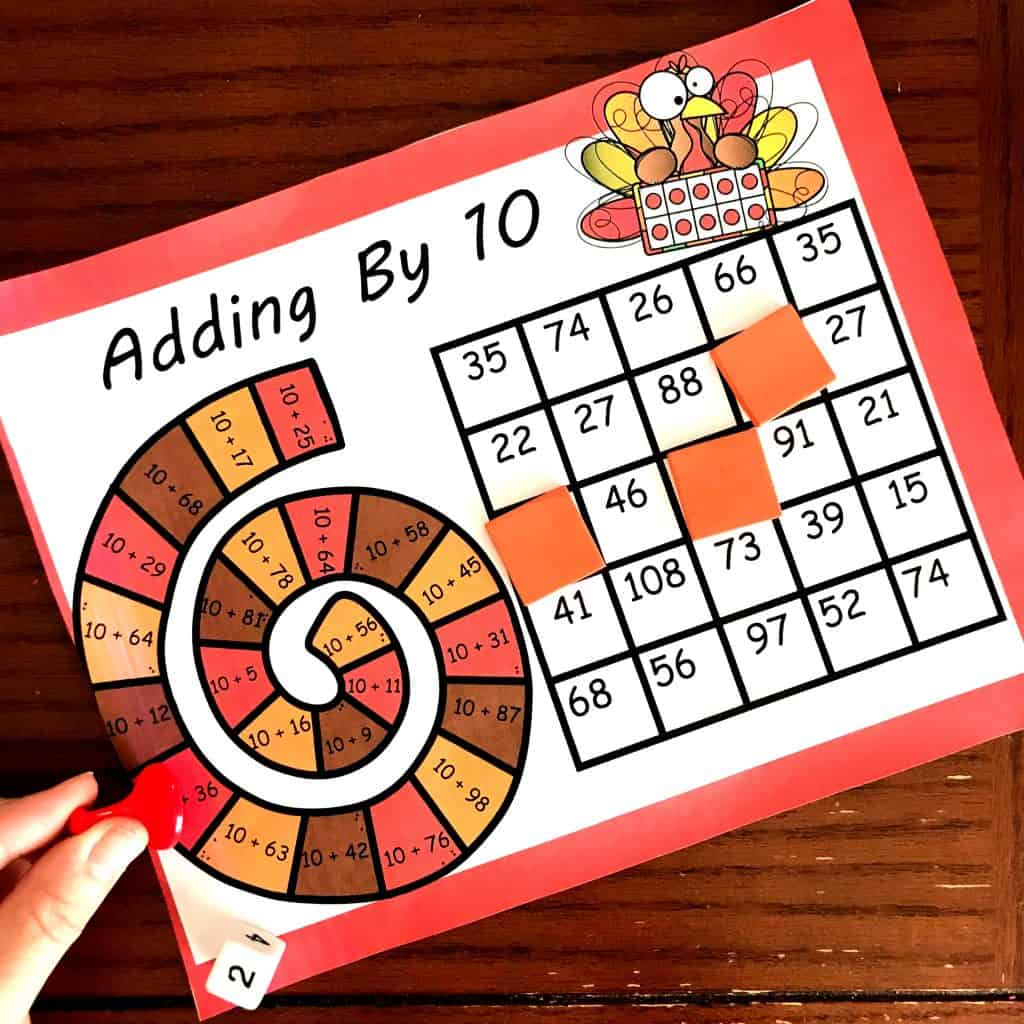 Adding by 10 game with paper covering numbers.