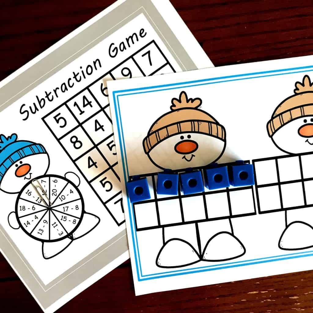 A snowmen subtraction games for kids printables on a table with game pieces.