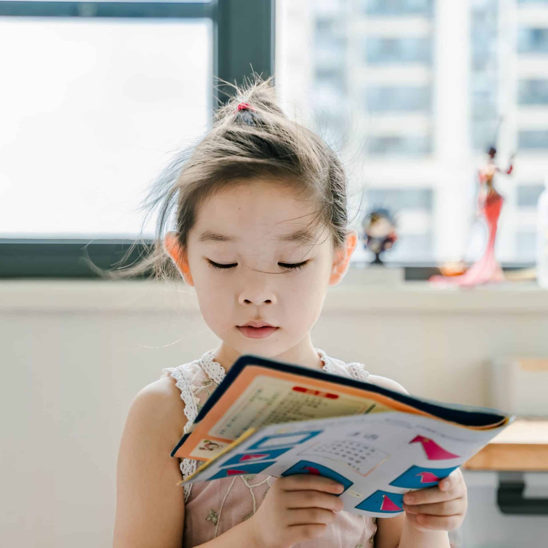 kindergartener reading a workbook